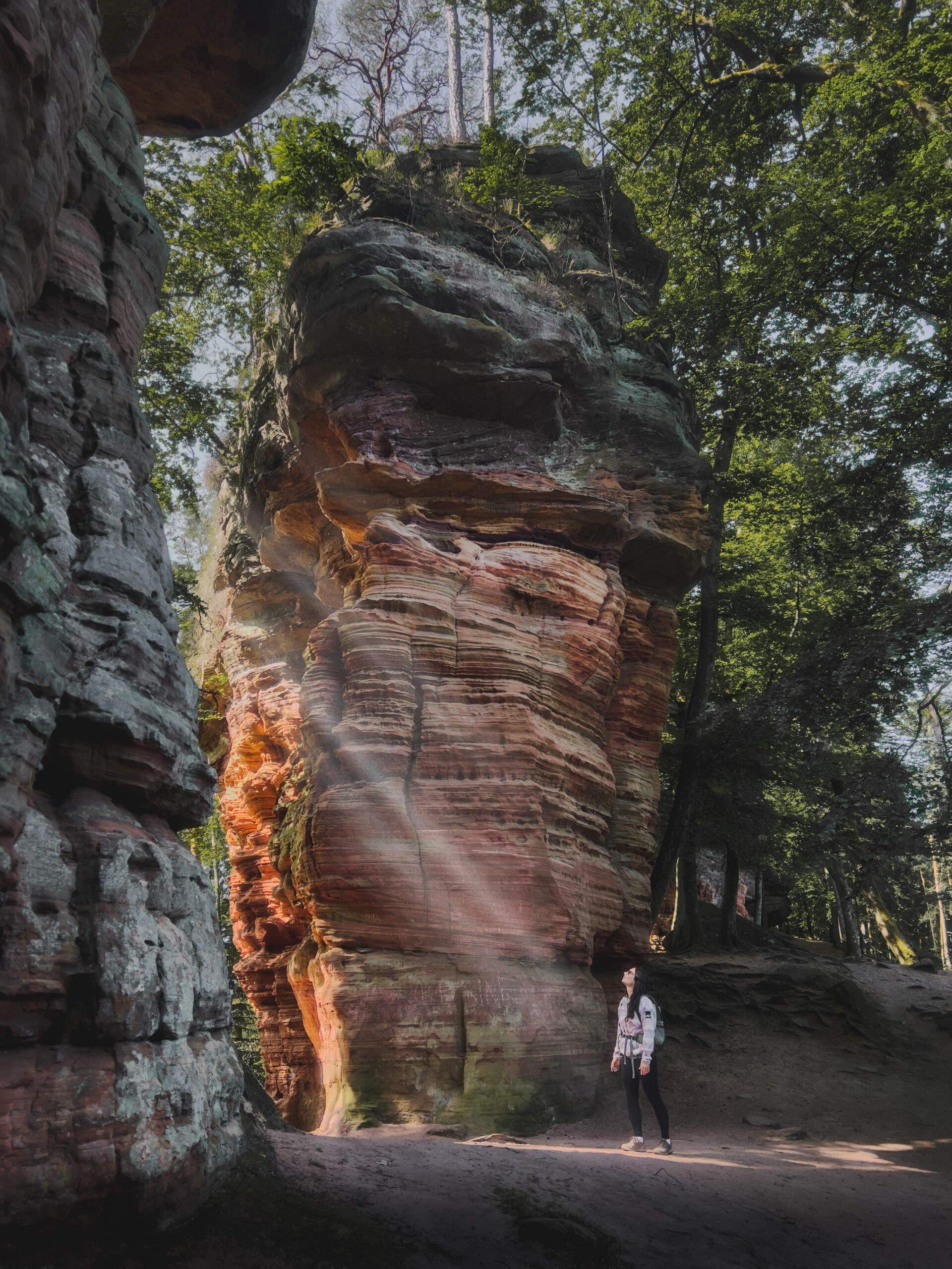 Sonnenlicht trift Frau in Öffnung der Altschlossfelsen in Rheinland-Pfalz