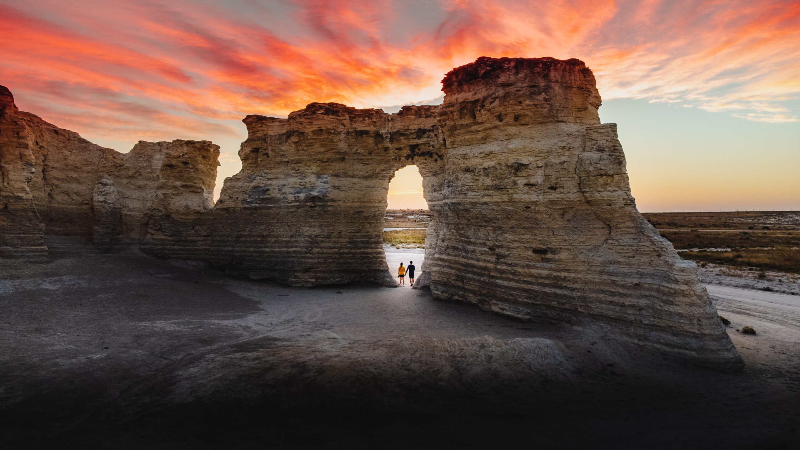 Couple standing in opening of Monument Rocks, Kansas during sunset